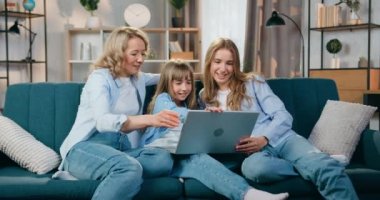 Aile kavramı, güzel, mutlu, gülümseyen anne ve iki kızının evdeki bilgisayardaki akrabalarıyla görüntülü sohbet etmesidir.