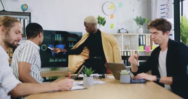 Conceito de trabalho de escritório onde atraente profissional inteligente diverso grupo masculino de programadores brainstorming sobre projeto de arranque conjunto usando informações sobre monitor digital — Vídeo de Stock