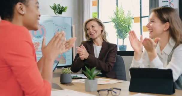 Sikeres üzletemberek csoportja, akik a csapat sikerét ünneplik tapsoló kezekkel tapsolnak az irodai megbeszélésen. — Stock videók