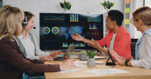 Líder mulher apresentando dados gráficos financeiros enquanto mostra a apresentação trabalhando em conjunto com colegas do sexo feminino no escritório — Vídeo de Stock