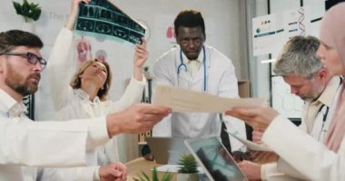 Tıp konsepti, klinikteki toplantı sırasında çeşitli profesyonel tıp çalışanlarının X-ray taraması raporları ve sonuçlarıyla birlikte çalışmalarının...