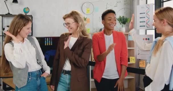 Vier van de gelukkige diverse zakenvrouwen geven high five samen tijdens team corporate brainstorm, vieren goed succesvol teamwork resultaat op corporate meeting in kantoor — Stockvideo
