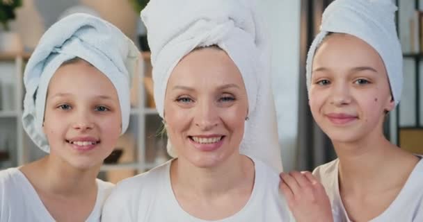 Hezký úsměv šťastný přátelský matka a její dvě dospívající dcery v froté ručníky pózovat na kameru v moderním domácím interiéru, zblízka — Stock video