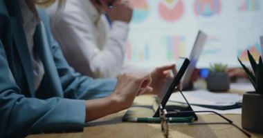 Başka bir çalışkan işçinin geçmişinde tablet bilgisayarında yazan iyi korunmuş kadın ellerine yakın çekim