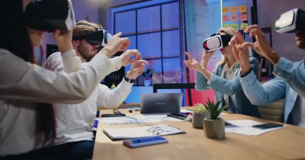 Workflow v kanceláři sympaticky koncentrovaných kvalifikovaných moderních spolupracovnic, které večer pracují na virtuální obrazovce s rozšířenými brýlemi pro realitu — Stock video