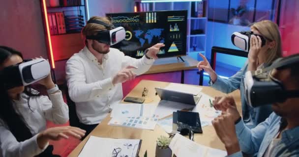 Concept de technologie moderne de sympathiques collègues multiethniques professionnels confiants qui travaillent sur écran virtuel dans des lunettes de réalité augmentée — Video