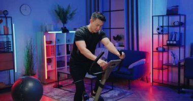 Çekici güçlü Asyalı sporcu. Spor kıyafetleri içinde. Akşamları staj yaparken bisiklete biniyor.