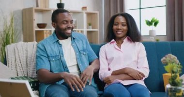 Çekici, mutlu, gülümseyen, Afro-Amerikan bir çiftin kamera önünde poz verdiği aile ilişkisi kavramı. Evin arka planında sarılmalar.