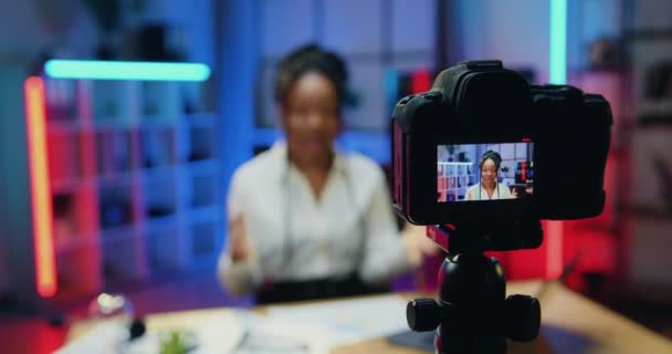 在摄像机屏幕上观看迷人而自信的高技能非洲裔美国女商人，她在晚上的办公室背景下为商业频道录制新的视频 — 图库视频影像