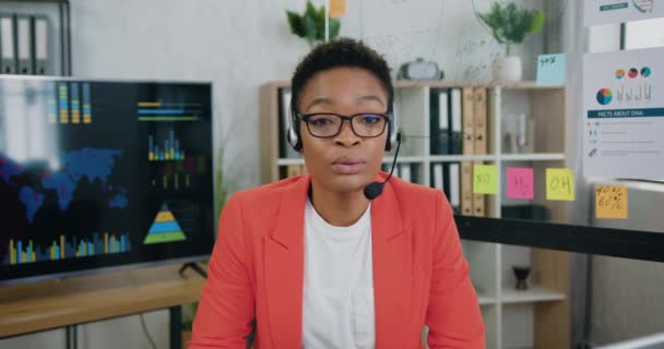 Portré arc gyönyörű latin nő visel headset, hogy konferencia videó hívás az irodában, beszél csevegés virtuális videó hívás zoom app az online találkozó — Stock videók