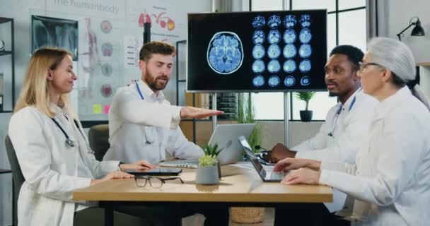 Simpático sonriente confiado experimentado diverso equipo de personas médicas haciendo asociación y símbolo de unidad, poniendo las palmas en las palmas de las manos en la habitación médica, vista frontal — Vídeo de stock