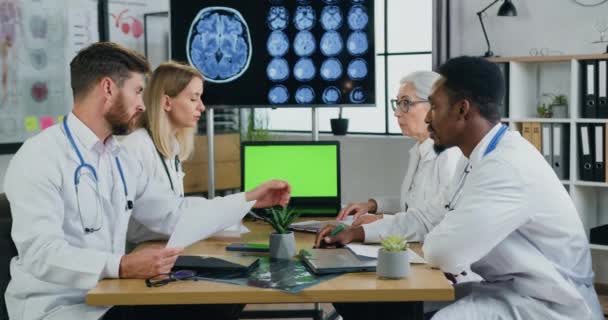 Workflow in kliniek waar aantrekkelijke zelfverzekerde slimme ervaren divers team van artsen die het houden van overleg in de moderne medische kantoor, slow motion — Stockvideo