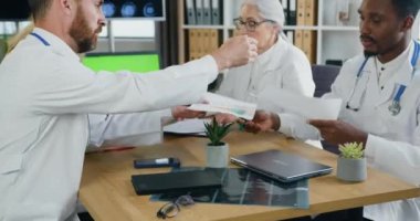 Çekici, yetenekli, çok kültürlü doktorların hızlandırılmış çekimi. Tıp odasında ortak brifing veriyorlar ve bilgi alışverişinde bulunuyorlar.