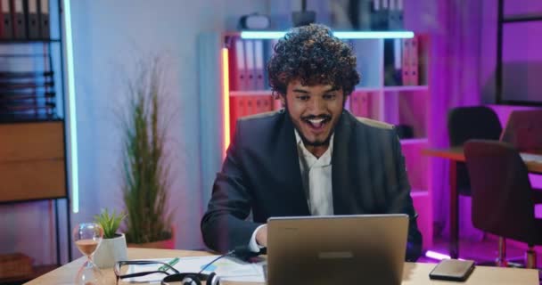 Επιτυχία και τύχη έννοια όπου όμορφος έκπληκτος χαρούμενος γενειοφόρος αραβός επιχειρηματίας χαίρεται από καλά νέα στην οθόνη του φορητού υπολογιστή στο γραφείο το βράδυ — Αρχείο Βίντεο
