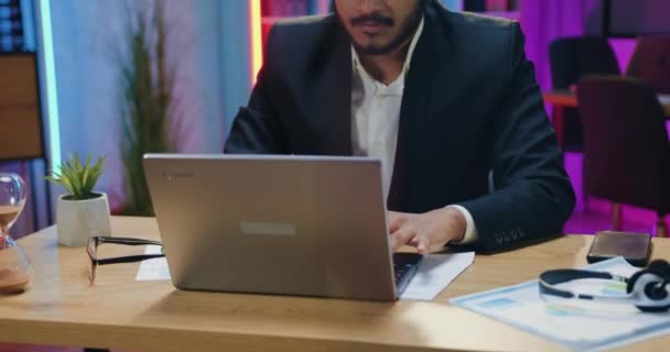 Business concept where handsome concentrated experienced modern bearded arabian businessman overtime working on laptop in evening office,front view — Stockvideo