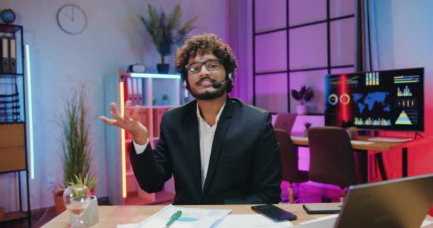 Atraktivní šťastný úsměv úspěšný kvalifikovaný vousatý muslimský podnikatel ve sluchátkách nahrávání nového videa pro obchodní kanál a tleskání rukou po ukončení záznamu — Stock video