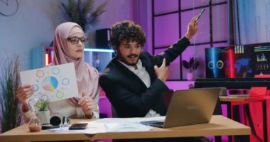İş ortaklarıyla çevrimiçi sohbet sırasında bilgisayarın önünde oturan ve ithalat ve ihracat göstergelerini açıklayan çekici, kendine güveni tam iki iş adamı.