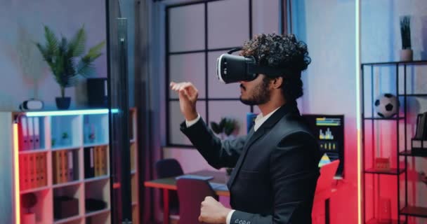 Handsome concentrated smart hardworking bearded muslim office worker working on virtual screen in special 3d glasses in workroom with night lightings — Vídeo de Stock