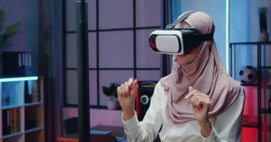 Çekici kendine güvenen, deneyimli, hafif menekşe tesettürlü çok yönlü iş kadını gece mesaisi sırasında özel 3D gözlükler takıyor.
