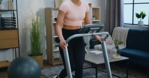 Portrait of charming fit sportive young african american woman in sportswear which walking on treadmill while training at home in the morning or daytime at leisure — Stock Video