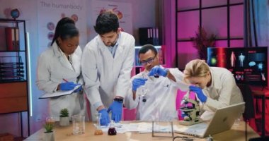 İyi görünümlü, kendine güvenen, gözlemci çeşitli doktor araştırma ekipleri akşam laboratuvarında birlikte çalışıyorlar. Mikroskop, kimyasal sıvılar ve mataralar kullanıyorlar. Kağıt raporları.
