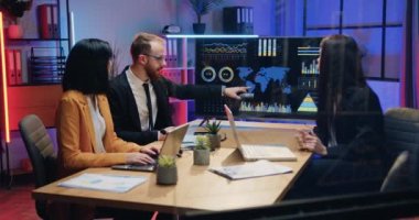 Akşamki ofiste çalışmak, iyi motive edilmiş, emek gerektiren, erkek ve kadın ofis yöneticilerinin ortak toplantı düzenlediği ve dijital beyaz tahtada sunumu tartıştığı yer.