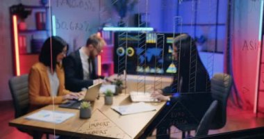 İyi görünümlü, iyi niyetli, yetenekli iş adamlarına cam duvardan bak. Akşam ofislerinde ortak proje üzerine beyin fırtınası yapıyorlar.