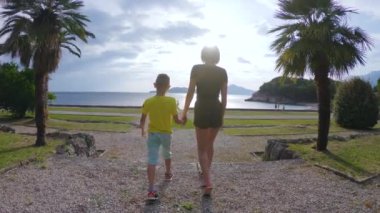 Genç bir kadın ve küçük oğlu yaz akşamı gün batımında merdiven boşluğuna doğru yürürken...