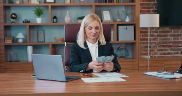 Business woman in office successful checking amount of cash money dollars counting finance salary rejoice with payment at workplace. — Video