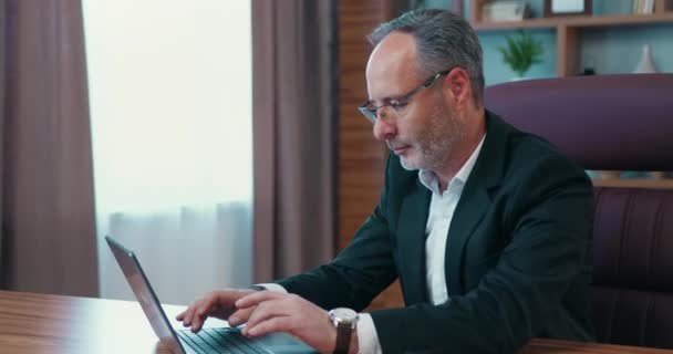 Focused middle age male ceo executive manager in suit working at laptop. Skilled company leader reviewing financial report. — Vídeo de stock