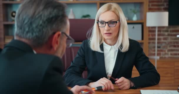Happy middle aged mature caucasian businesswoman shaking hands with male partner, making agreement or thanking in modern office greeting and congratulating candidate after successful interview. — Vídeo de stock