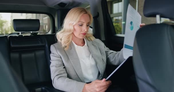 Poważna Bizneswoman Czytająca Gazety Statystykami Samochodzie Służbowym Portret Wykonawczej Kobiety — Wideo stockowe