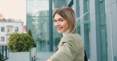 Klasik takım elbiseli bir kadının şehir sokaklarında güvenle yürüdüğünü ve kamerada beni takip ettiğini görüyorum. Konseptimi takip et. Yavaş çekim.