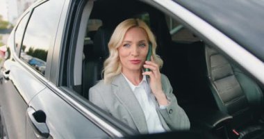 Cep telefonu kullanan orta yaşlı çekici bir kadına yakın çekim. Ön koltukta oturan sarışın bir kadın. Ulaşımı paylaşıyor ve akıllı telefondan konuşuyor. Yavaş çekim