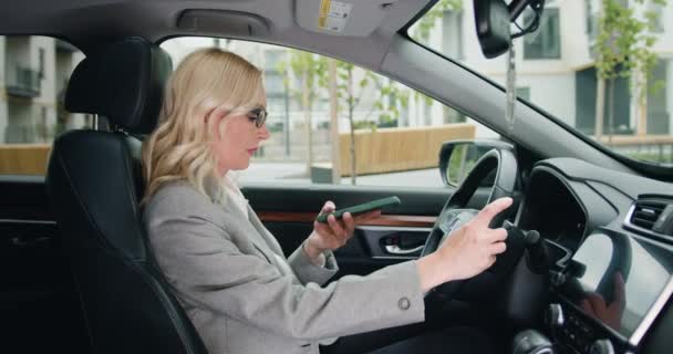 Skupiona Bizneswoman Siedzi Kierownicą Samochodu Podczas Nagrywania Wiadomości Głosowej Smartfonie — Wideo stockowe