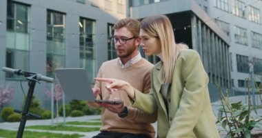 İş ortakları proje verilerini göstermek için dışarıda buluşmak için dizüstü bilgisayar kullanıyor. Yavaş çekim.