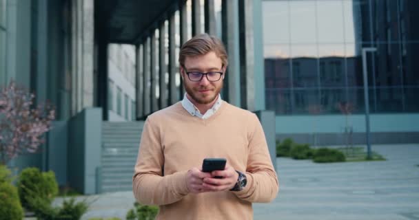 Felice Giovane Uomo Barbuto Rosso Abbigliamento Casual Camminare Con Smartphone — Video Stock