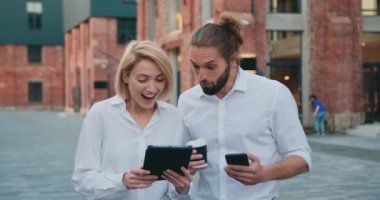 Genç ve mutlu bir çift dizüstü bilgisayara bakıyor, dışarıda iyi haberlerle e-posta okuyor ve kazanmayı kutluyor. Yavaş çekim.