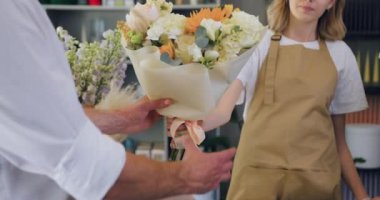 Close up of man buying bouquet of flowers. Shopping concept. Slow motion.