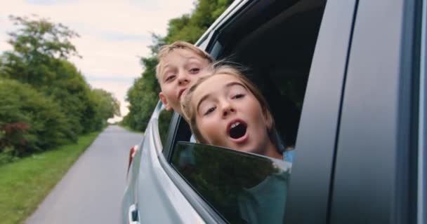 Beztroskie Dzieci Wychyliły Się Przez Okno Samochodu Uśmiechnęły Szczęśliwa Rodzina — Wideo stockowe