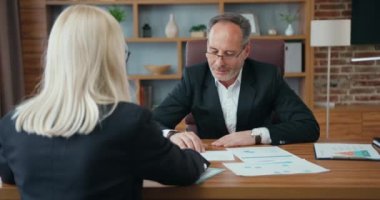 Yakışıklı, memnun, sakallı iş adamının başarılı sarışın kadın ortağıyla konuştuğu, iyi tasarlanmış iş yerlerindeki istişare sırasında ortak sözleşmenin ayrıntıları hakkında beyin fırtınası yaptığı bir iş konsepti.