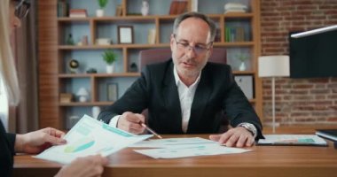 İyi görünümlü, başarılı, sakallı bir ofis müdürü, kasıtlı bir iş kadınıyla aynı masada oturuyor ve ortak iş anlaşmasının detaylarına kafa yoruyor.