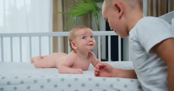 Lúdico Recién Nacido Sonriendo Acostado Boca Abajo Una Cuna Hermano — Vídeo de stock