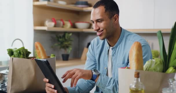 Usmívající Mladý Černoch Pomocí Elektronického Tabletu Kuchyni Muž Hledající Recept — Stock video