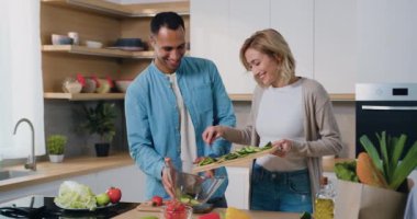 Mutfakta çok ırklı bir çift sabahları birlikte yemek pişiriyorlar. Sağlıklı bir yaşam tarzı ve evde iyi vakit geçirmenin zevki..