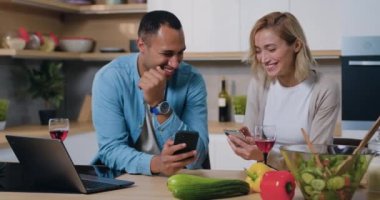 Afrika kökenli Amerikalı erkek ve kadın mobil uygulama kullanıyor, havalı filtrelerin tadını çıkarıyor akıllı telefonları kullanarak birlikte vakit geçiriyorlar. Çift evdeki cep telefonundan alışveriş yapmayı seviyor. Yavaş çekim.