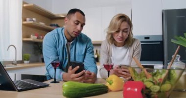 Mutfakta oturan mutsuz, genç bir çift. Afro-Amerikalı bir adam telefonda rahatsız bir kadına bir şey gösteriyor. Aile çatışması. Yavaş çekim.