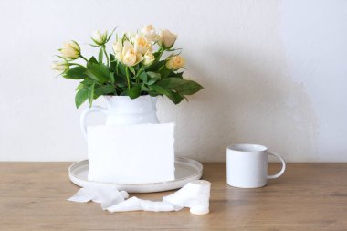 Bahar, yaz durgun hayat sahnesi. Klasik düğün tarzı kadınsı fotoğraf, çiçekli kompozisyon. Beyaz vazoda pembe güller ve bir fincan kahve..