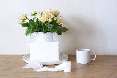 Bahar, yaz durgun hayat sahnesi. Klasik düğün tarzı kadınsı fotoğraf, çiçekli kompozisyon. Beyaz vazoda pembe güller ve bir fincan kahve..