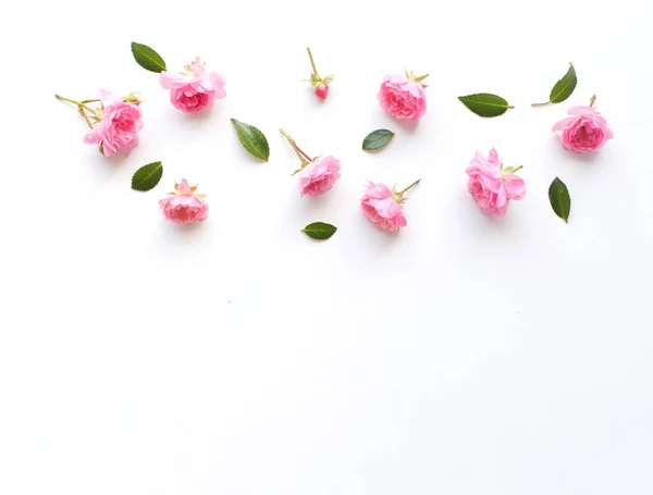 Stilvolles Archivfoto. Frühling feminine Szene, florale Komposition. Dekoratives Banner, Ecke aus schönen rosa Rosen. Weißer Tischhintergrund. Flache Lage, Draufsicht. Stockbild